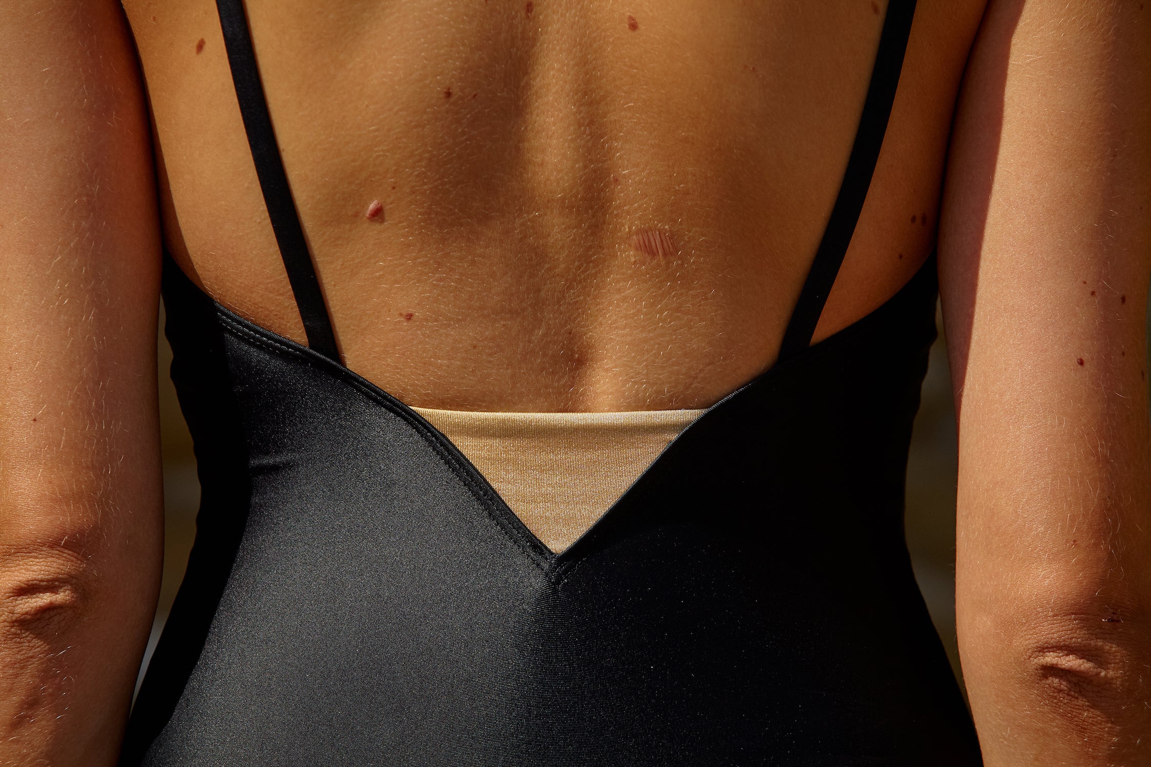 Initial S Maillot de bain femme 1 pièce noir avec triangle doré éco responsable fabrication française écologique nager bronzer plonger nylon recyclé swimwear swimsuit black coal gold triangle sustainable made in france econyl recycled nylon beachwear made from plastic waste natural beauty